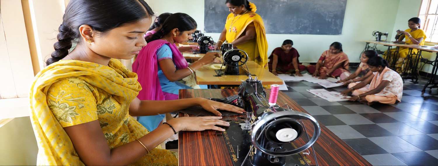 Women learning tailoring and stitching skills through economic empowerment program in India